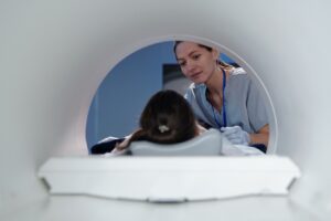 MRI technician looking at a patient as they move into the MRI machine for a sedation MRI procedure. 