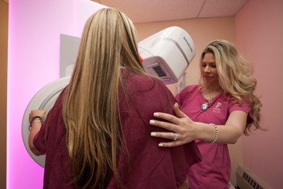 patient and technician with mammography machine
