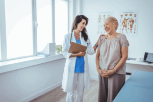 A patient talking to a health care provider, both are smiling and laughing.