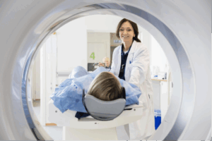 A radiologist smiling to her patient who is about to enter an MRI machine. 