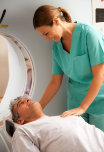 Close Up of a Female MRI Tech Attending to a Male Patient Lying on Outside of the MRI Machine Tube