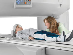 A child laying down inside an open MRI machine.