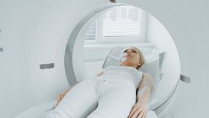 A Woman Lies on Her Back Inside an MRI Machine with a Serene Expression on Her Face