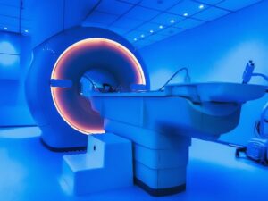 An Examination Room Illuminated in Blue Lighting with an MRI Machine in the Center of It