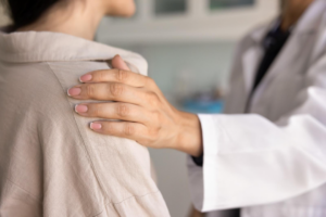 The hand of a doctor on the shoulder of a patient in a consoling manner. 